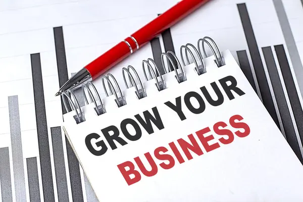 GROW YOUR BUSINESS text written on a notebook with pen on chart