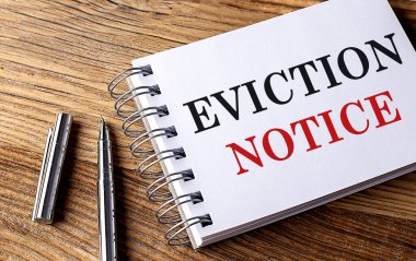 Tahta zemin üzerinde kalem olan bir defterde EVICTION Bildirisi metni