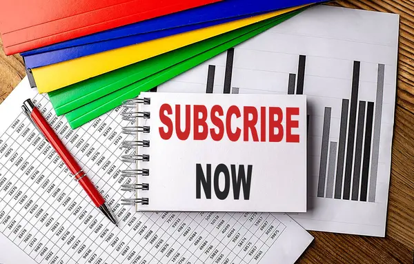 SUBSCRIBE NOW text on notebook with pen, folder on a chart background