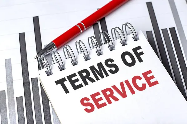 TERMS OF SERVICE text written on a notebook with pen on chart