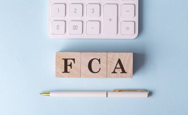 FCA, kalem ve hesap makineli ahşap küpler üzerine, finansal konsept