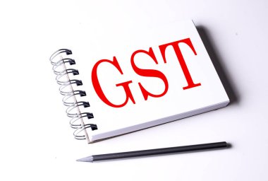 Beyaz arkaplanda bir defter üzerinde GST metni