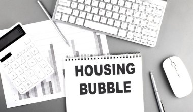 Gri arkaplandaki not defterine çizelge ve klavye ile yazılmış bir ev balonu metni, iş konsepti