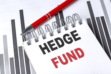 Gri arkaplan üzerine kalem ve hesap makinesiyle yazılmış HEDGE FUND metni