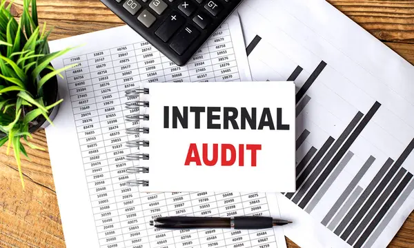 INTERNAL AUDIT text on notebook with chart and calculator