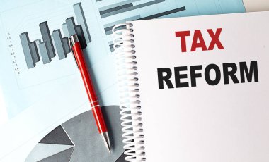 Not defterinde, arkaplanda kalem bulunan Vergi REform metni