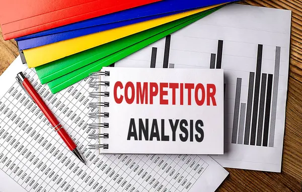 COMPETITOR ANALYSIS text on notebook with pen, folder on a chart background