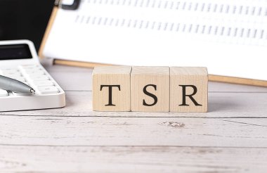 TSR - Tahta blok üzerinde pano ve hesap makinesiyle toplam hissedar iade sözcüğü