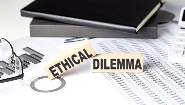 ETHİAL DILEMMA - tahta blok üzerinde çizelge ve defter ile metin