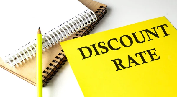 DISCOUNT RATE text written on yellow paper with notebook