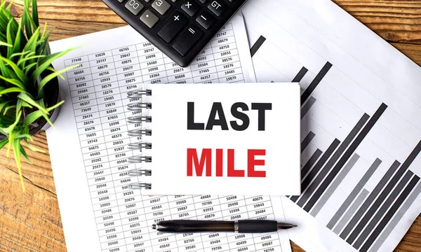LAST MILE text on notebook with chart and calculator
