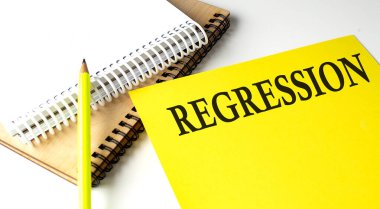 Not defteriyle sarı kağıda yazılmış REGRESSION metni