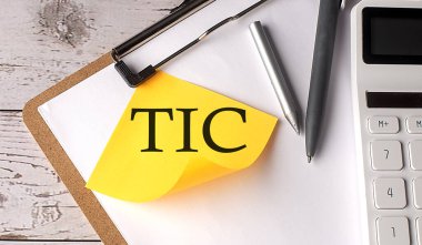 Hesap makinesi, kalem ve pano ile sarı yapışkan üzerine COMMMON sözcüğünde TIC TENANCY