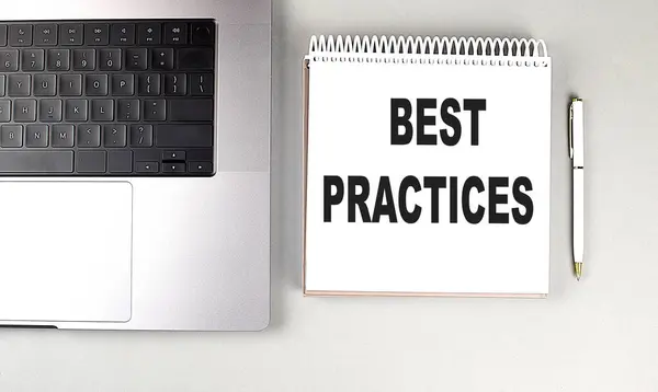 BEST PRACTICES text on a notebook with laptop and pen