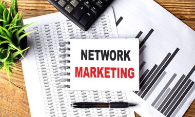 Çizelge ve hesap makineli defter üzerinde NETWorK MARKETING metni