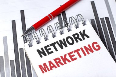 Çizelgesinde kalem olan bir defter üzerine yazılmış NETWork MarkeTING metni