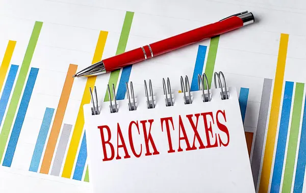 Текст Back Taxes Блокноті Концепцією Бізнесу Діаграми Перо Стокове Зображення
