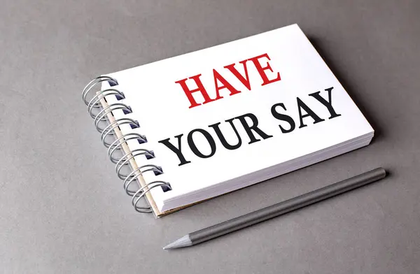 HAVE YOUR SAY word on a notebook on grey background