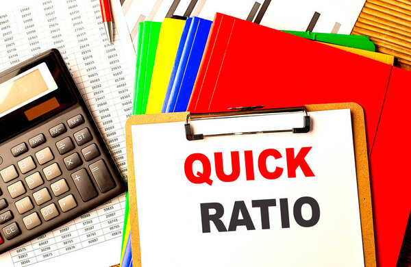 QUICK RATIO text written on a paper clipboard with chart and calculator