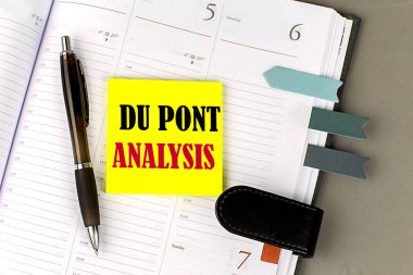 DU PONT ANALYSIS word on yellow sticky with office tools on daily planner clipart