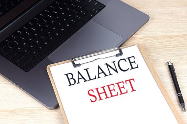 Diz üstü bilgisayarda kağıt panoya yazılmış balans SHEET metni