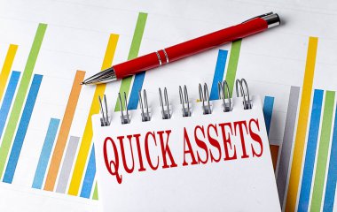 QUICK ASSETS text on the notebook on chart with pen .  clipart