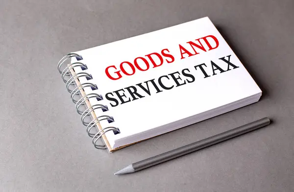 GOODS AND SERVICES TAX text on a notebook on the grey background.