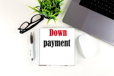 Not defterine dizüstü bilgisayarı, faresi ve kalemi olan DOWN Ödeme Metni . 