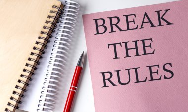 Beyaz arka planda ofis araçları ile pembe kağıt üzerindeki kuralları kırın