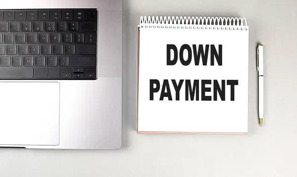 DOWN PAYMENT text on a notebook with laptop and pen