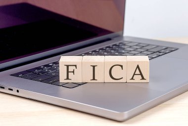 FICA sözcüğü dizüstü bilgisayarda ahşap blok, iş kavramı
