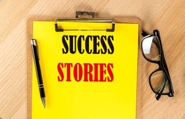 SUCCESS STORIES Ahşap zemin üzerinde sarı kağıt üzerinde metin