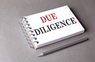 Gri arkaplanda bir defter üzerindeki DILIGENCE metni . 