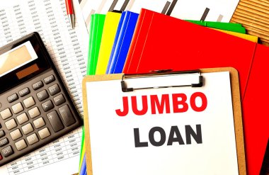 JUMBO LOAN text on a clipboard with calculator and color folder .  clipart