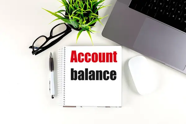 ACCOUNT BALANCE text on a notebook with laptop, mouse and pen .