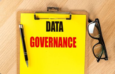 DATA GOVERNANCE kalem ve gözlüklü sarı bir kağıt üzerinde metin. 