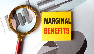 MARGINAL BENEFITS text on a sticky on chart background .  clipart