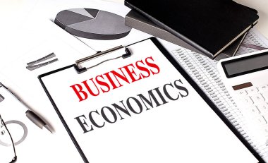 BUSINESS ECONOMICS text on clipboard on a chart with notebook and calculator.  clipart