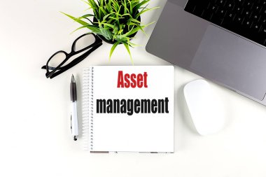 Dizüstü bilgisayarı, faresi ve kalemi olan bir dizüstü bilgisayardaki ASSET MANAGEMENT metni . 