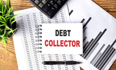 Hesap makinesi ve kalemle çizelgedeki bir dizüstü bilgisayarda DEBT ColleCsion metni . 