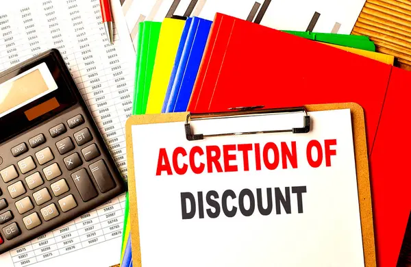 stock image ACCRETION OF DISCOUNT text on a clipboard with calculator and color folder . 