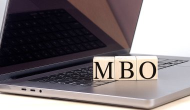 MBO word on a wooden block on a laptop , business concept.  clipart