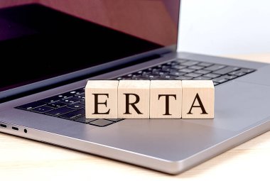 Diz üstü bilgisayarda ahşap bir blokta ERTA kelimesi, iş konsepti. 