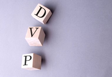 DVP word on a wooden block on gray background .  clipart