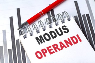 MODUS OPERANDI text on a notebook on chart with pen .  clipart
