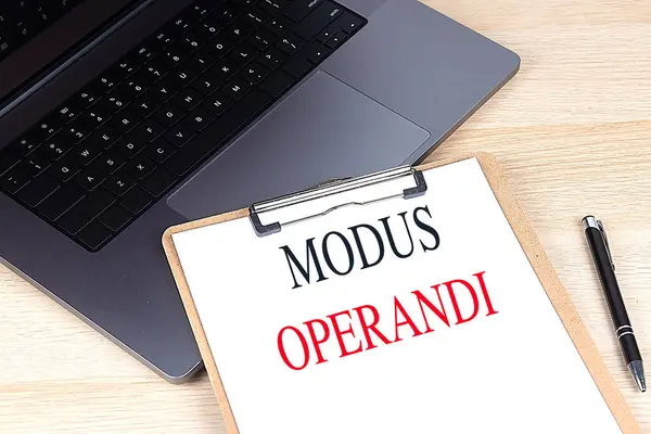 stock image MODUS OPERANDI text on a clipboard on laptop. 