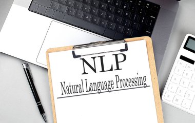 Bilgisayardaki bir panoda hesap makinesi ve kalemle NLP kelimesi . 