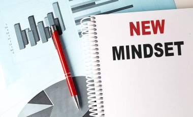 Çizelge arkaplanındaki bir defterde NEW MindSET metni . 