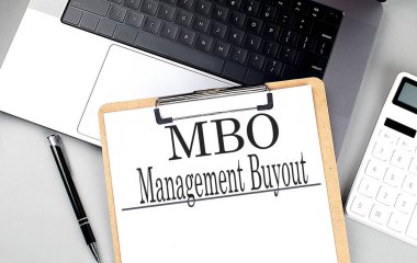 MBO- MANAGEMENT BUYOUT kelime bir pano üzerinde hesap makinesi ve kalem ile . 