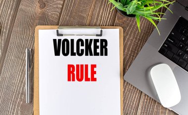 Diz üstü bilgisayarı, faresi ve kalemi olan bir pano kağıdındaki VOLCKER kural metni . 